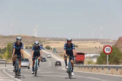 foto de movistar team circulando por una carretera nacional a la vez que otros turismos